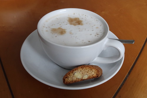 Café latte mit einem Stück Cantuccini