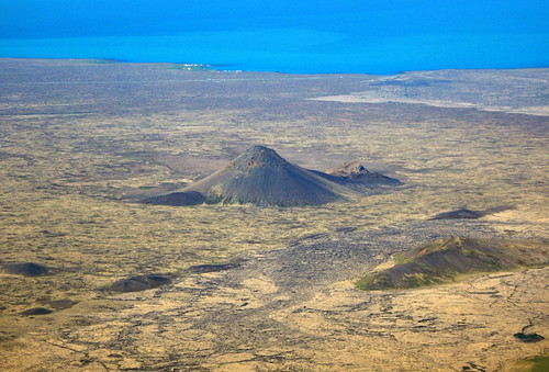 Aerial shot of a volcano by the ocean in Iceland from a commercial Icelandair flight