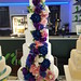 Five tiered wedding cake with a cascade of silk flowers.