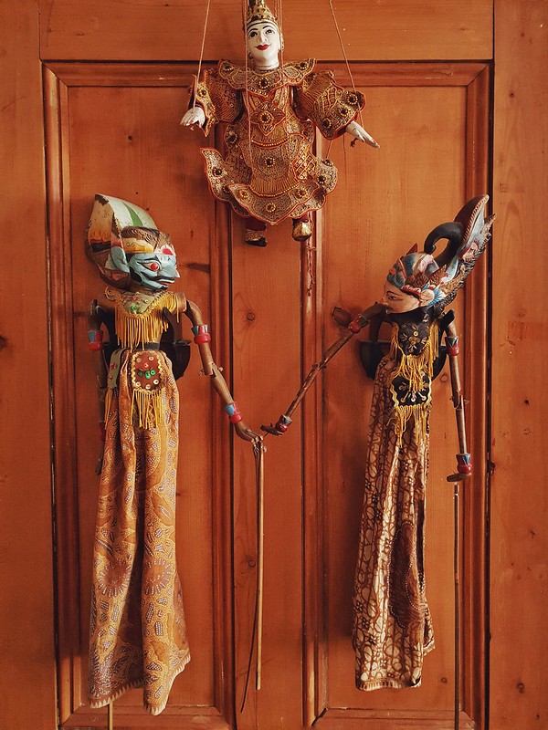 Indonesian puppets holding hands on a door