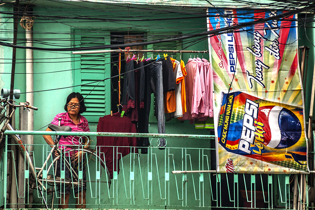 Woman on balcony and Pepsi ad--Saigon