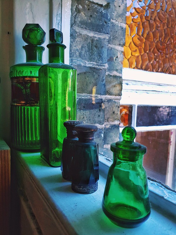Green glass bottles in a windowsill