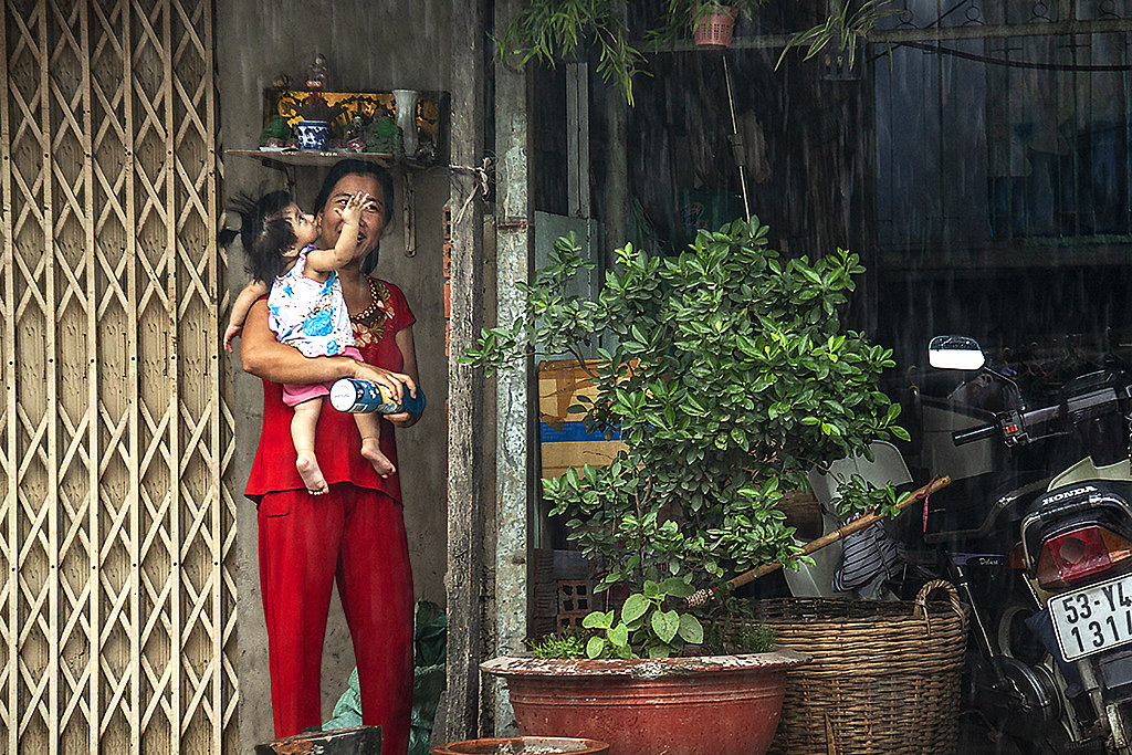 Toddler marveling at rain--Saigon