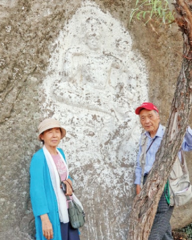 Dr So Gilsu with his wife at a rock-carved Buddha at Arab Khan Cheena, Swat Valley.