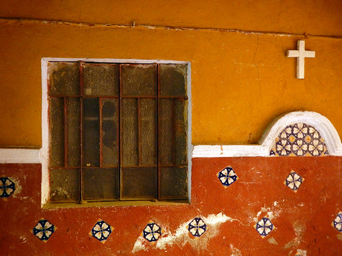 Talavera tile wall and a barred window in Puebla, Mexico