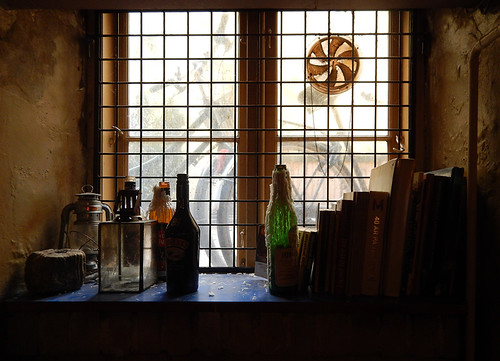 A basement pub window with glass bottles and whatnot in Copenhagen, Denmark