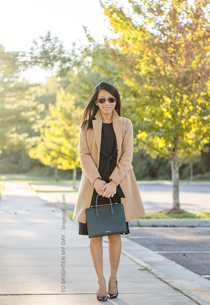 camel long coat, green tie front midi dress, bottle green tote with gold bar, aquamarine ring, burgundy patent pumps