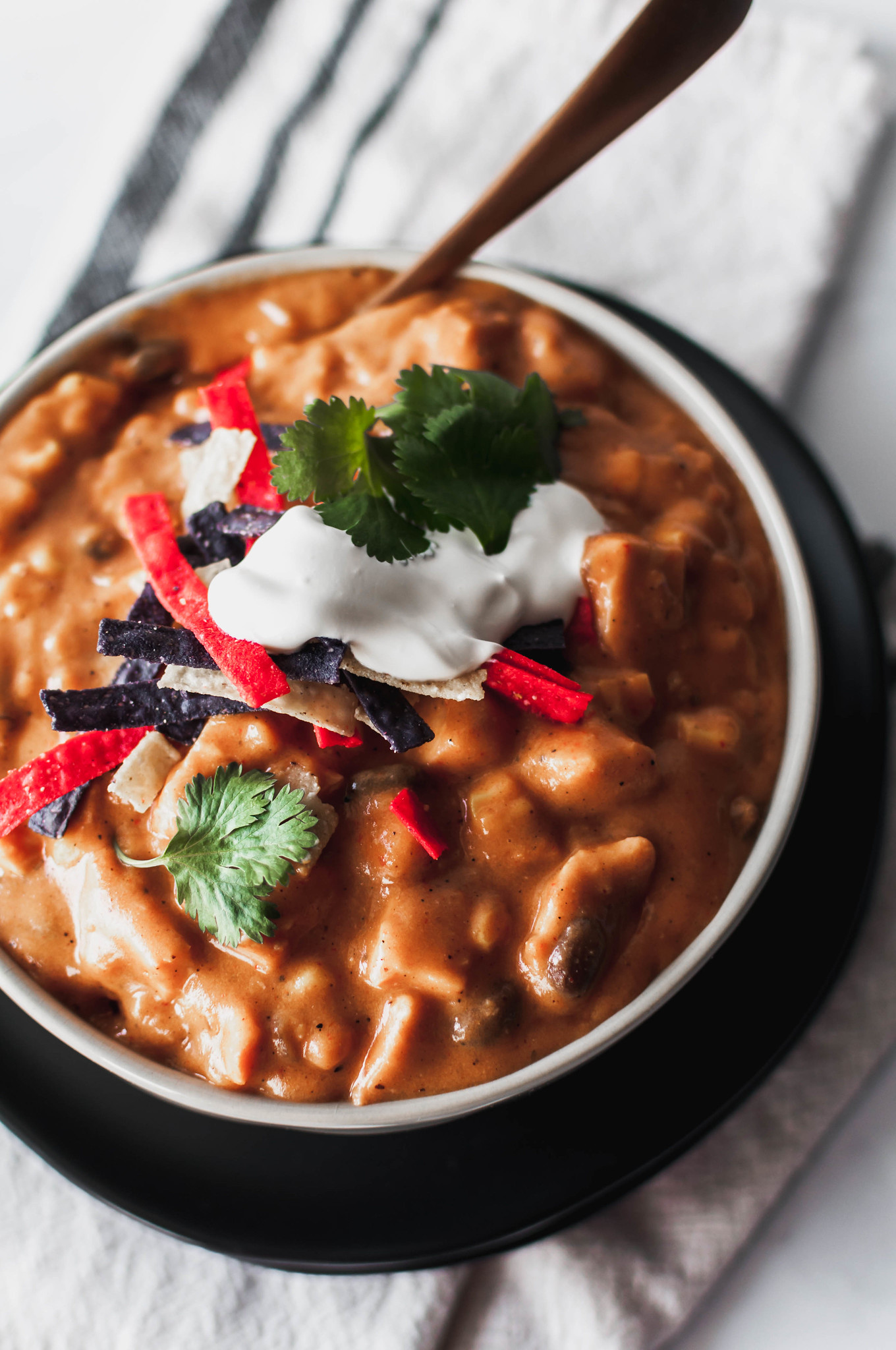 Chicken Enchilada Soup is creamy, spicy and packed full of enchilada flavor. The perfect slow cooker soup for fall.