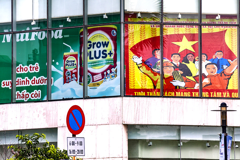 Capitalist ad next to Communist propaganda--Saigon
