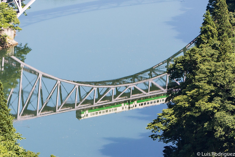 Reflejos del tren de la línea Tadami sobre el río Tadami