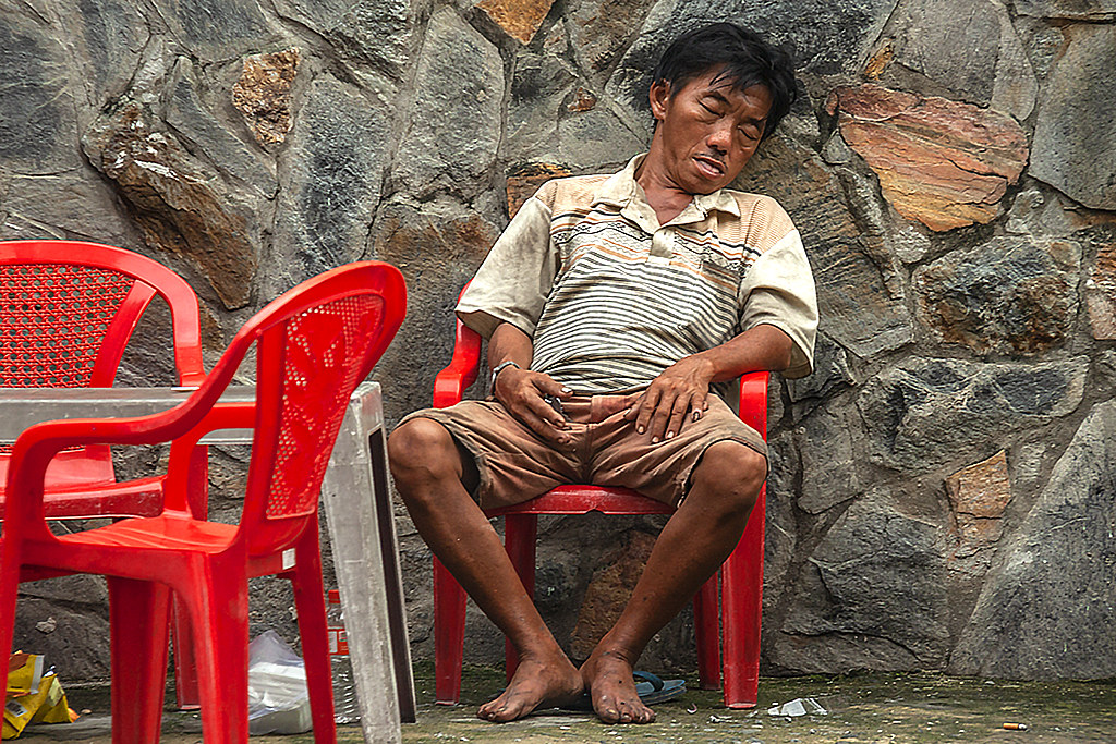 Man dozing on red chair in my neighborhood--Saigon